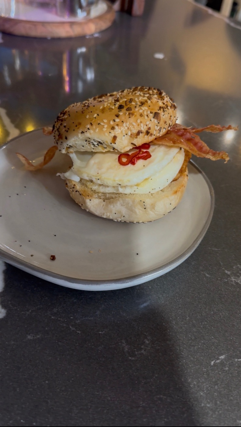 Breakfast bagel with egg, bacon and chili